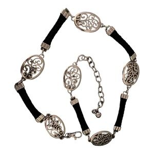 Belt, silver oval medallions connected with black leather cords.